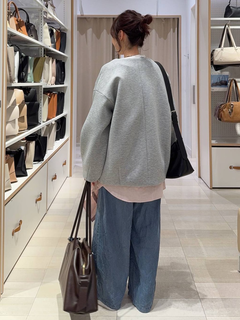 グレー系のブルゾン、ピンク系のシャツ/ブラウス、ブラウン系のボストンバッグを着用したレディースの春コーディネートの7枚目の写真