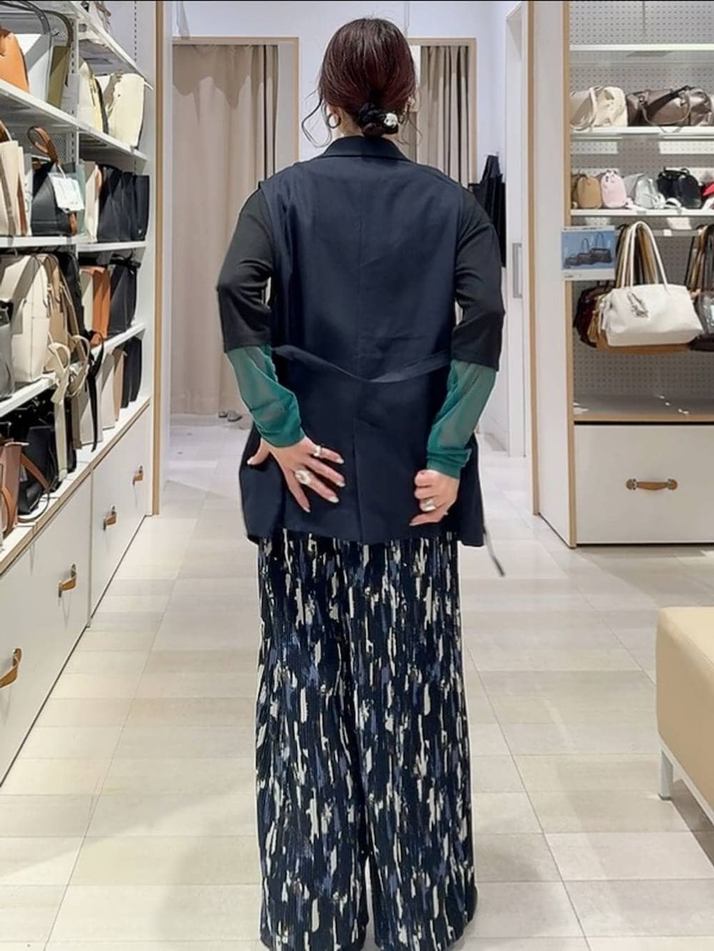 ブラック系のその他シューズ、ブラック系のボストンバッグ、ブルー系のベストを着用したレディースの春コーディネートの5枚目の写真