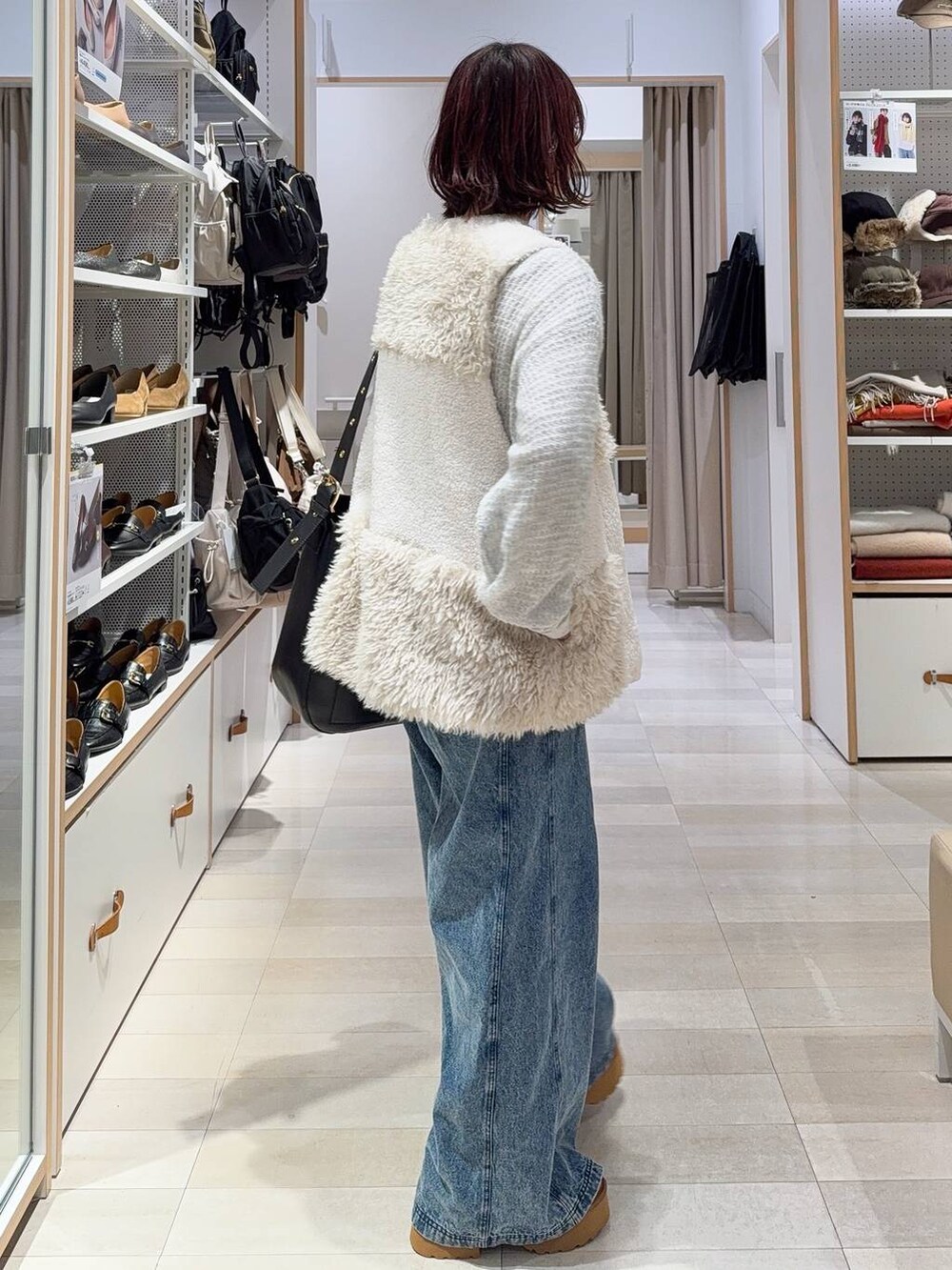 ブラック系のショルダーバッグ、グレー系のニット/セーター、イエロー系のブーツを着用したレディースの冬コーディネートの5枚目の写真