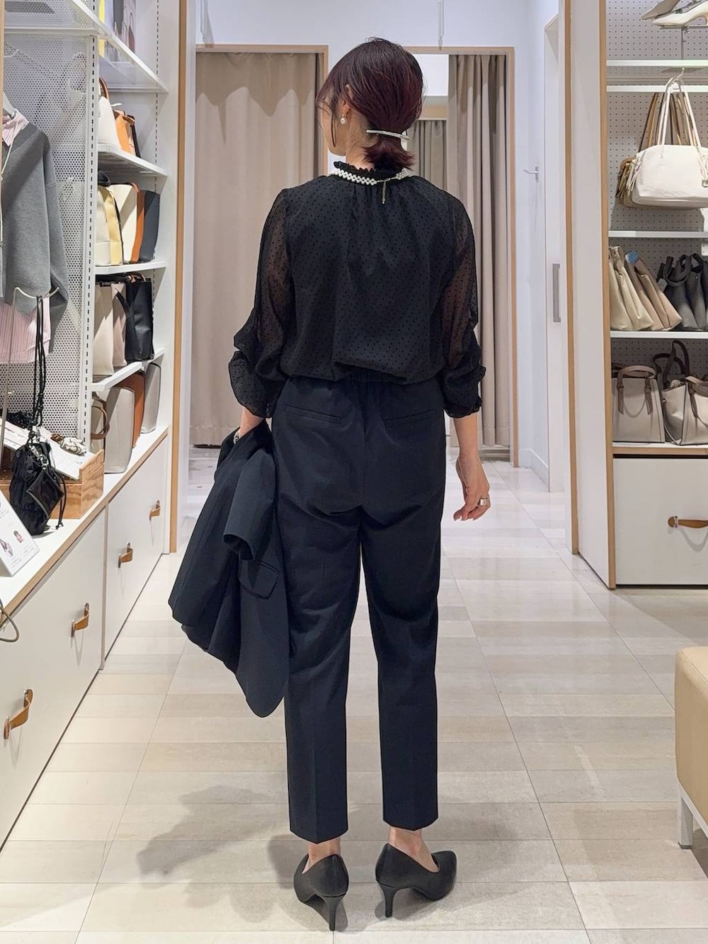 ブラック系のショルダーバッグ、ブルー系のスラックス、ブルー系のノーカラージャケットを着用したレディースの冬コーディネートの7枚目の写真