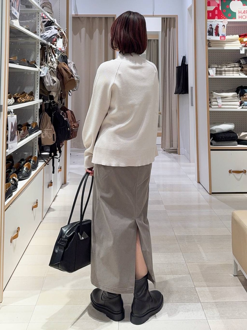 ブラウン系のバックパック/リュック、ブラウン系のスカート、ブラック系のブーツを着用したレディースの冬コーディネートの8枚目の写真