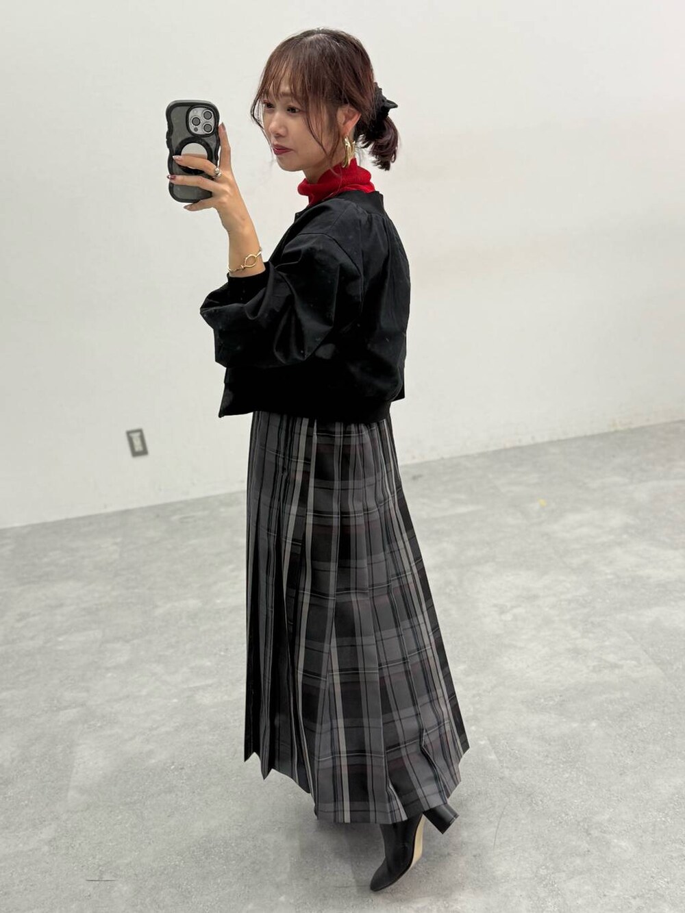 ブラック系のTシャツ/カットソー、グレー系のスカート、ブラック系のブーツを着用したレディースの秋コーディネートの4枚目の写真