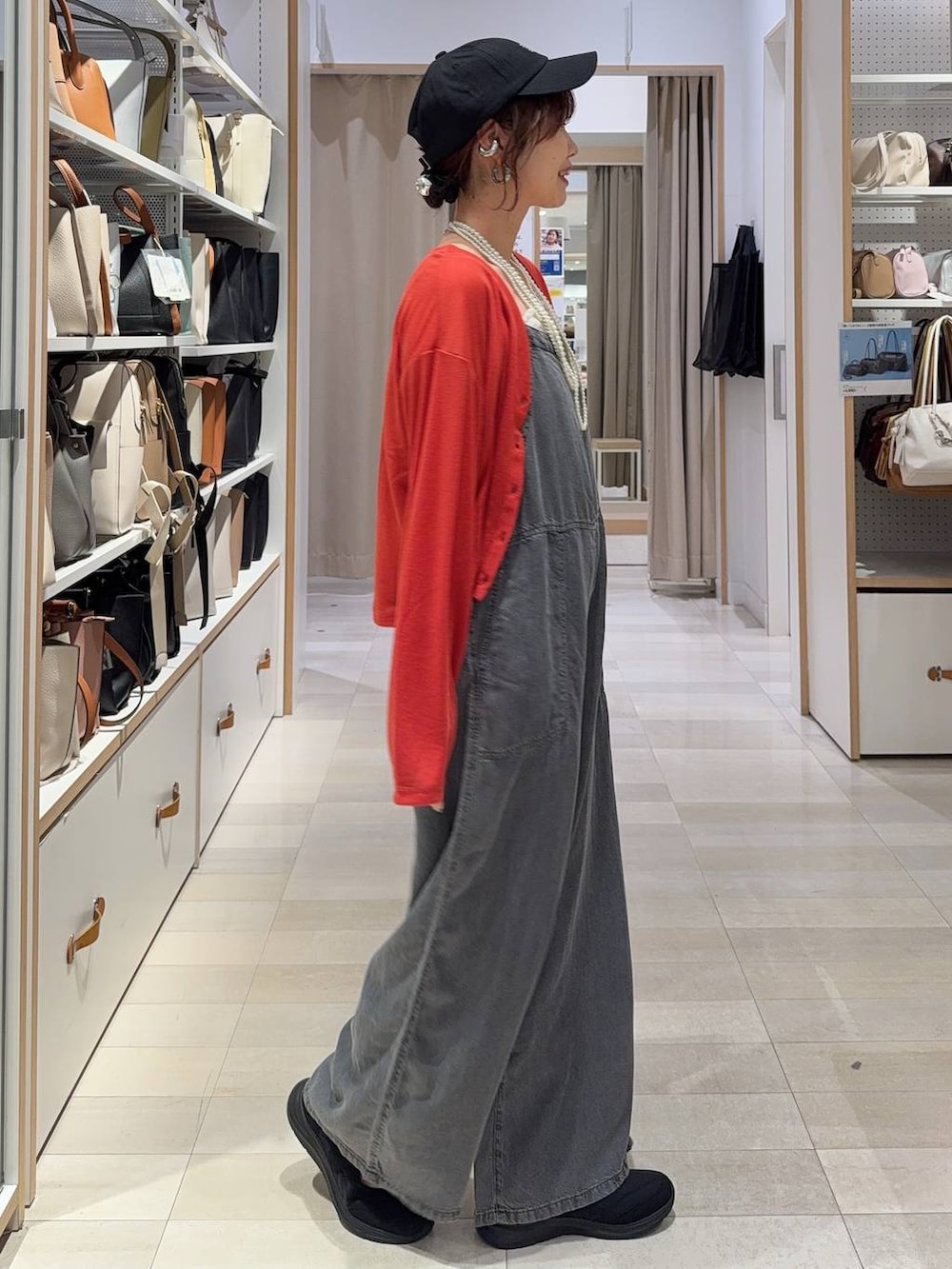 ブルー系のトートバッグ、オレンジ系のカーディガン/ボレロ、ブラック系のスニーカーを着用したレディースの春コーディネートの6枚目の写真