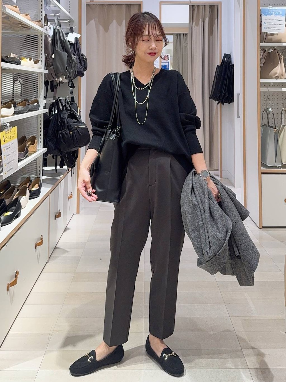 ブラック系のローファー、ブラウン系のボストンバッグ、ブラック系のスウェットを着用したレディースの秋コーディネートの3枚目の写真