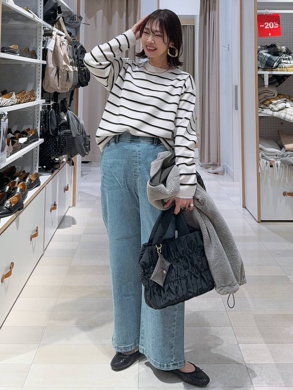 ブラウン系のショルダーバッグ、ブラウン系のスカート、ホワイト系のTシャツ/カットソーを着用したレディースの冬コーディネートの3枚目の写真