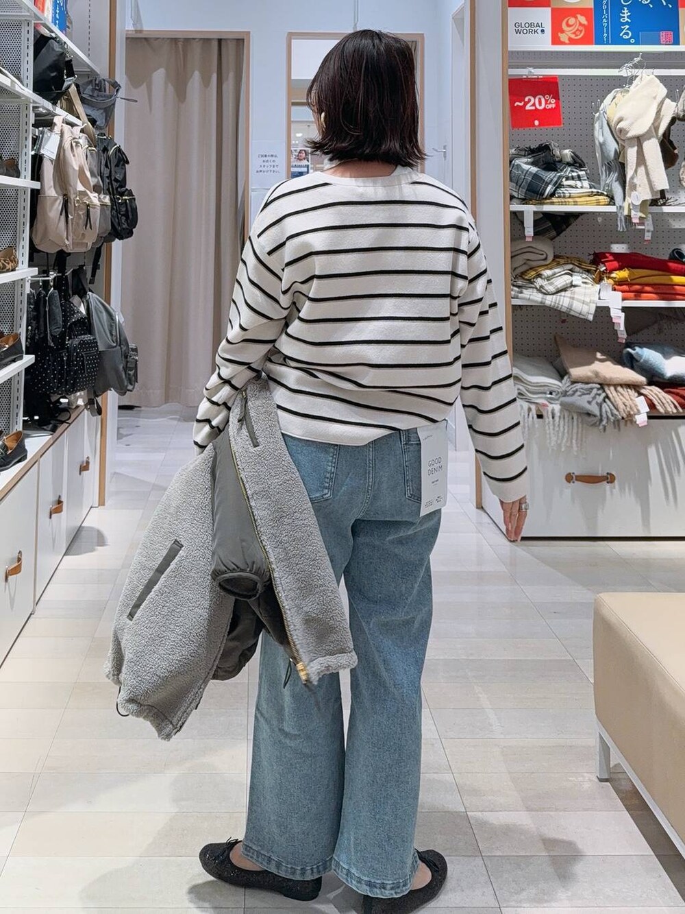 ブラック系のバレエシューズ、グレー系のブルゾン、ブルー系のデニムパンツを着用したレディースの冬コーディネートの8枚目の写真