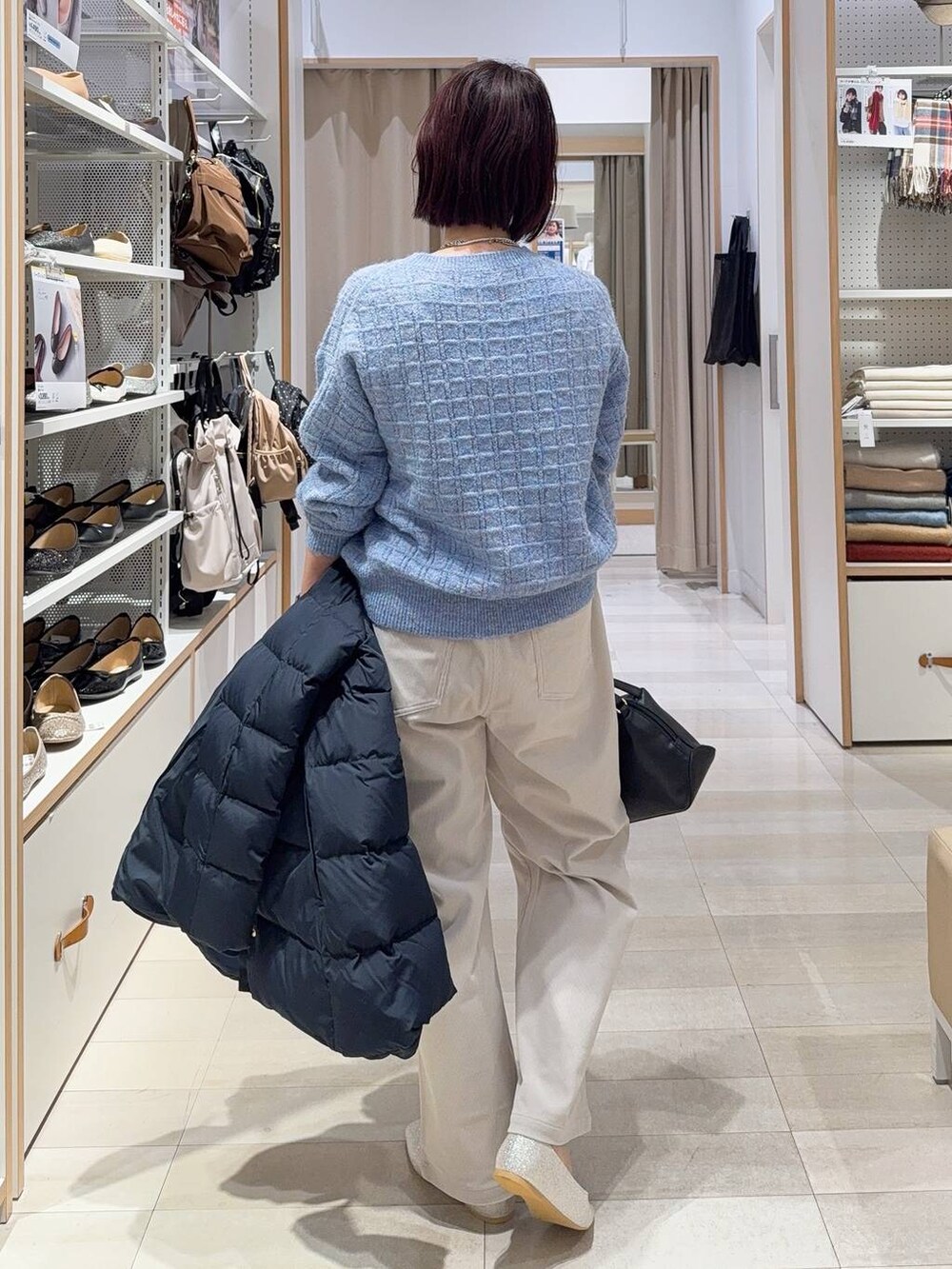 ブラック系のショルダーバッグ、シルバー系のパンプス、ブルー系のダウンジャケット/コートを着用したレディースの秋コーディネートの7枚目の写真