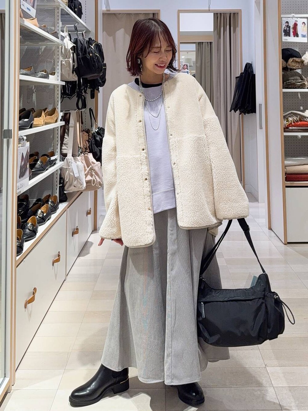 ブラック系のショルダーバッグ、グレー系のスカート、パープル系のスウェットを着用したレディースの冬コーディネートの2枚目の写真