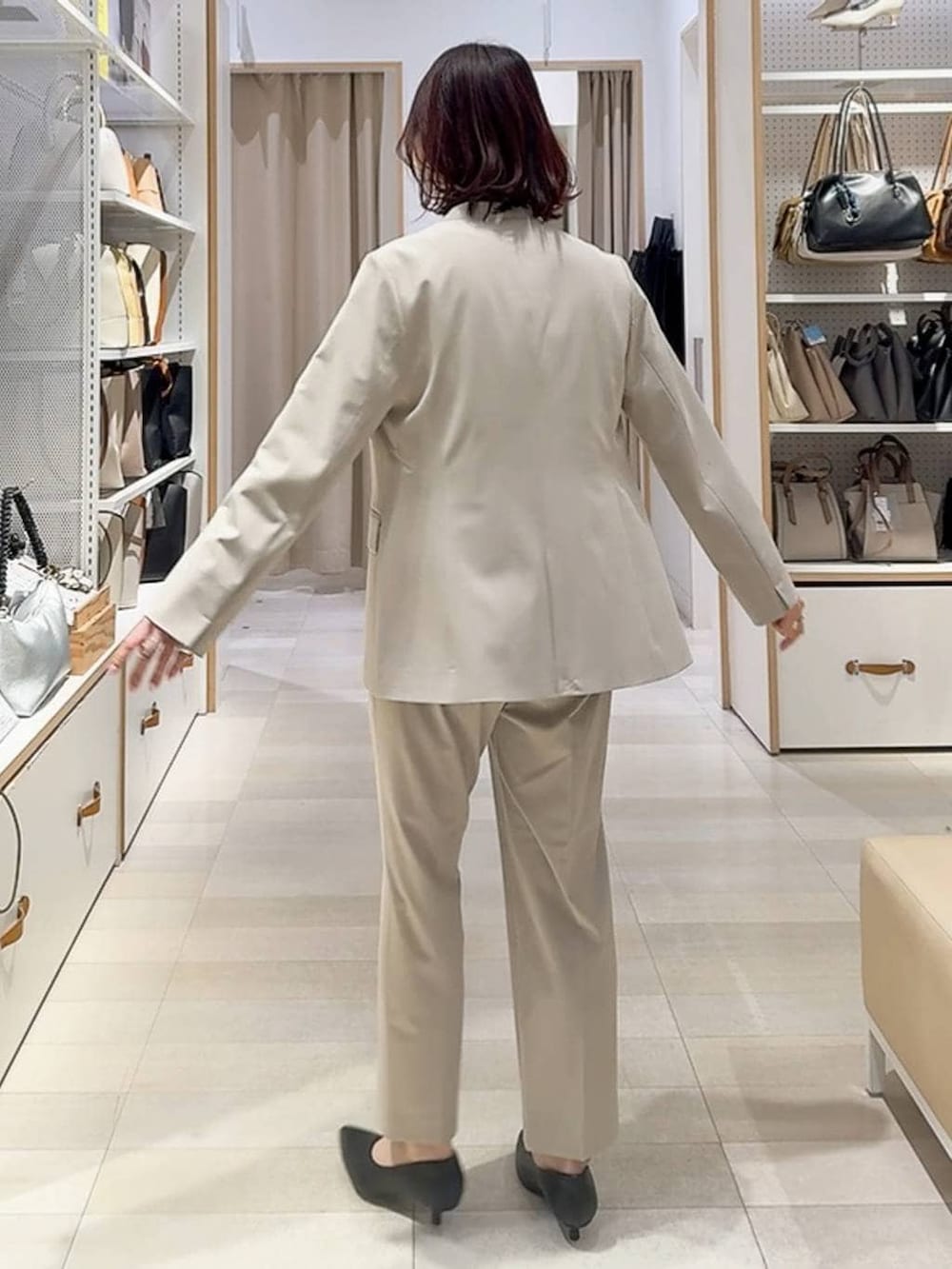 ベージュ系のスラックス、ベージュ系のノーカラージャケット、グレー系のトートバッグを着用したレディースの冬コーディネートの5枚目の写真