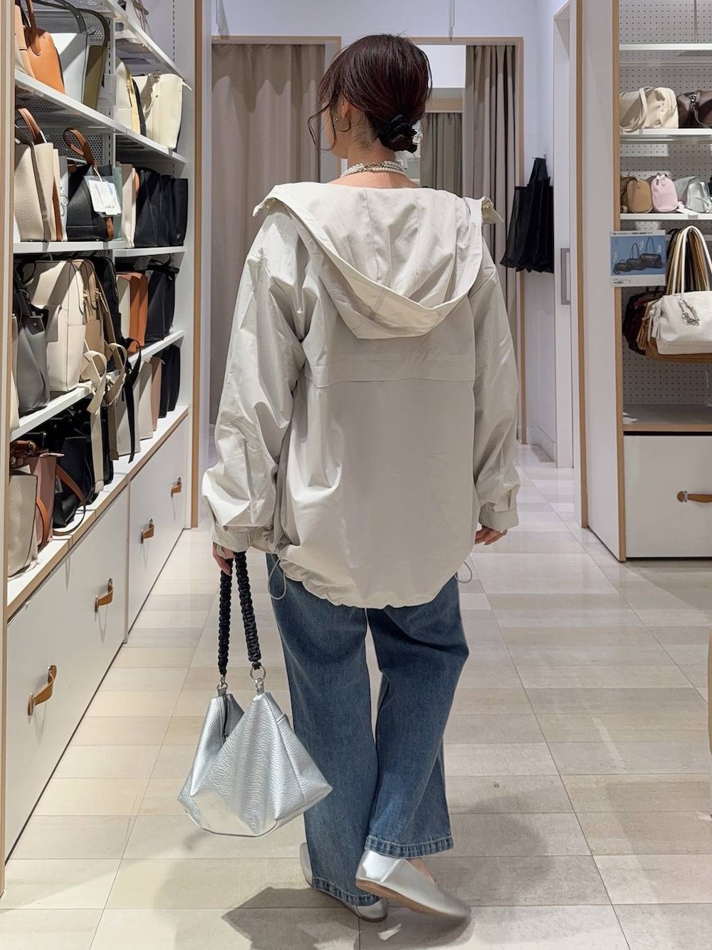 ホワイト系のパンプス、ブルー系のデニムパンツ、ベージュ系のマウンテンパーカーを着用したレディースの春コーディネートの4枚目の写真