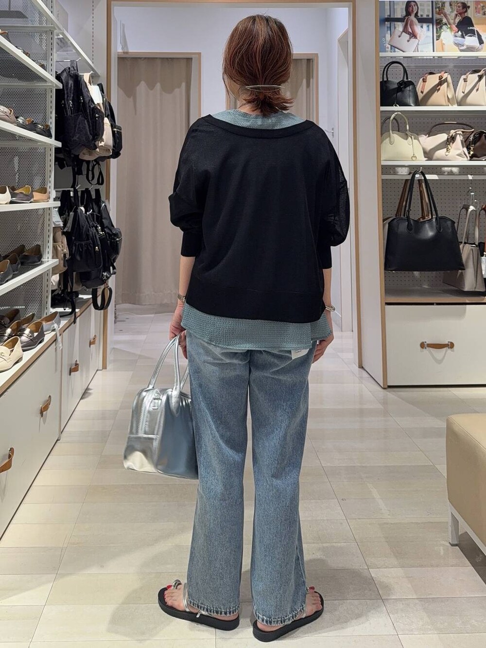 ブルー系のデニムパンツ、グレー系のボストンバッグ、ブラック系のカーディガン/ボレロを着用したレディースの夏コーディネートの7枚目の写真