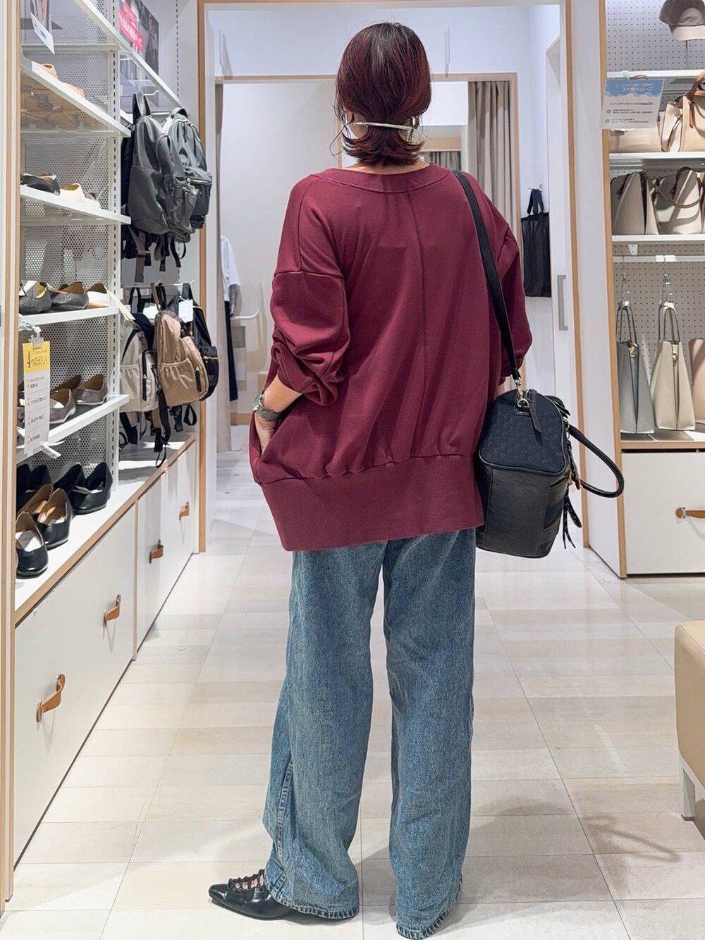 ホワイト系のキャミソール、ブルー系のデニムパンツ、ブラック系のボストンバッグを着用したレディースの秋コーディネートの10枚目の写真