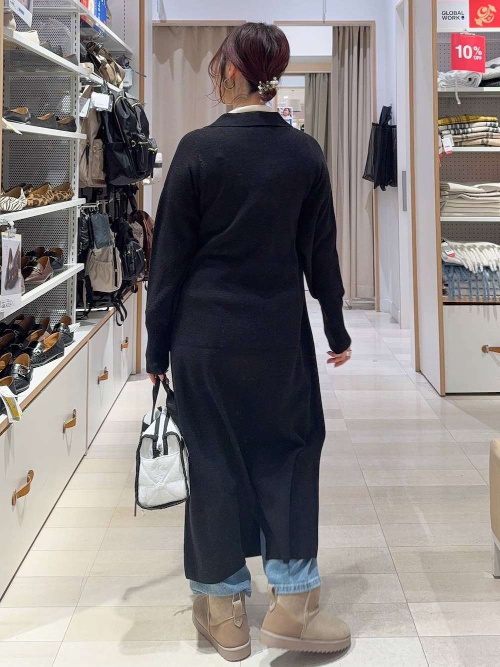 グリーン系のカーディガン/ボレロ、ホワイト系のボストンバッグ、ブラック系のワンピースを着用したレディースの冬コーディネートの7枚目の写真