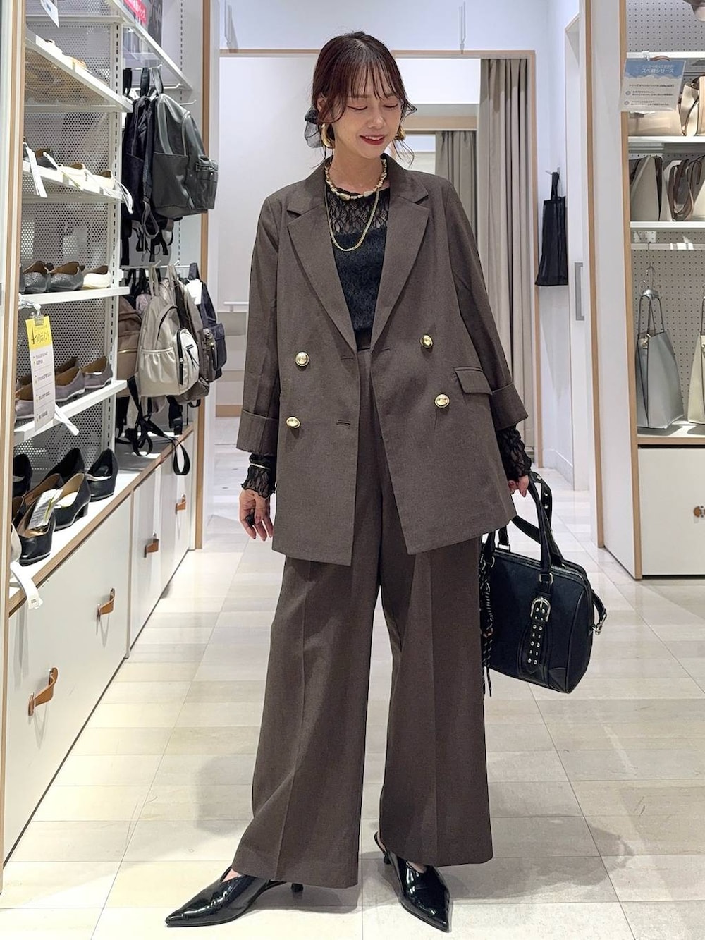 ブラック系のキャミソール、ブラウン系のテーラードジャケット、ブラウン系のスラックスを着用したレディースの秋コーディネートの3枚目の写真