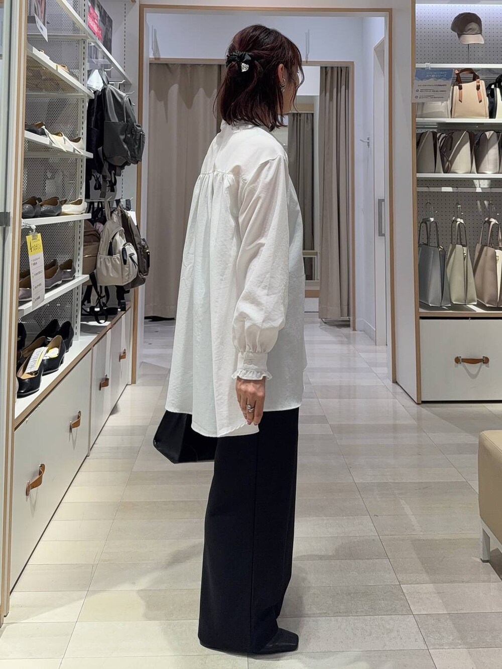 グレー系のカーディガン/ボレロ、ブラック系のショルダーバッグ、ホワイト系のシャツ/ブラウスを着用したレディースの秋コーディネートの5枚目の写真