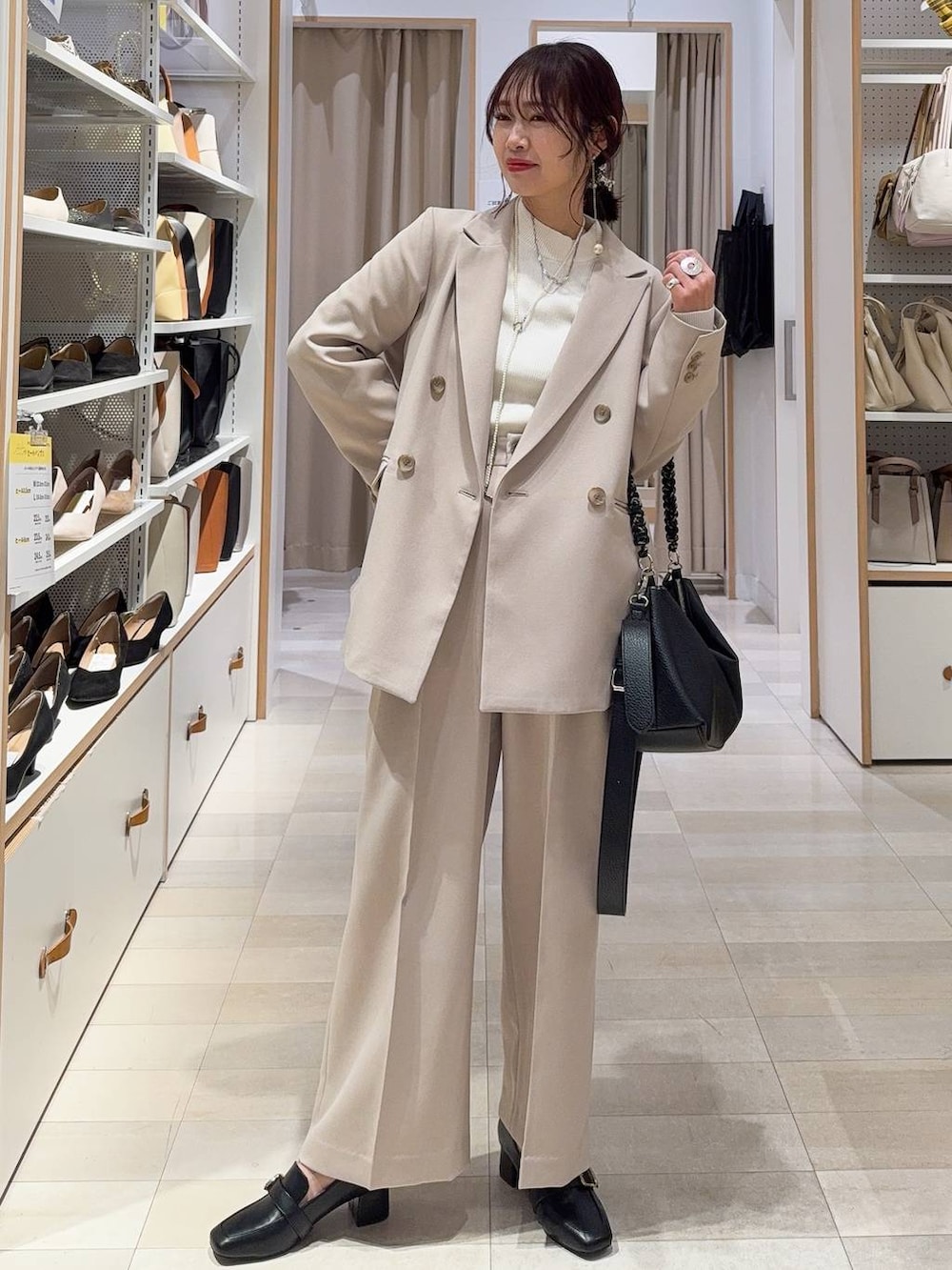 グレー系のワンピース、ベージュ系のテーラードジャケット、ゴールド系のネックレスを着用したレディースの冬コーディネートの4枚目の写真