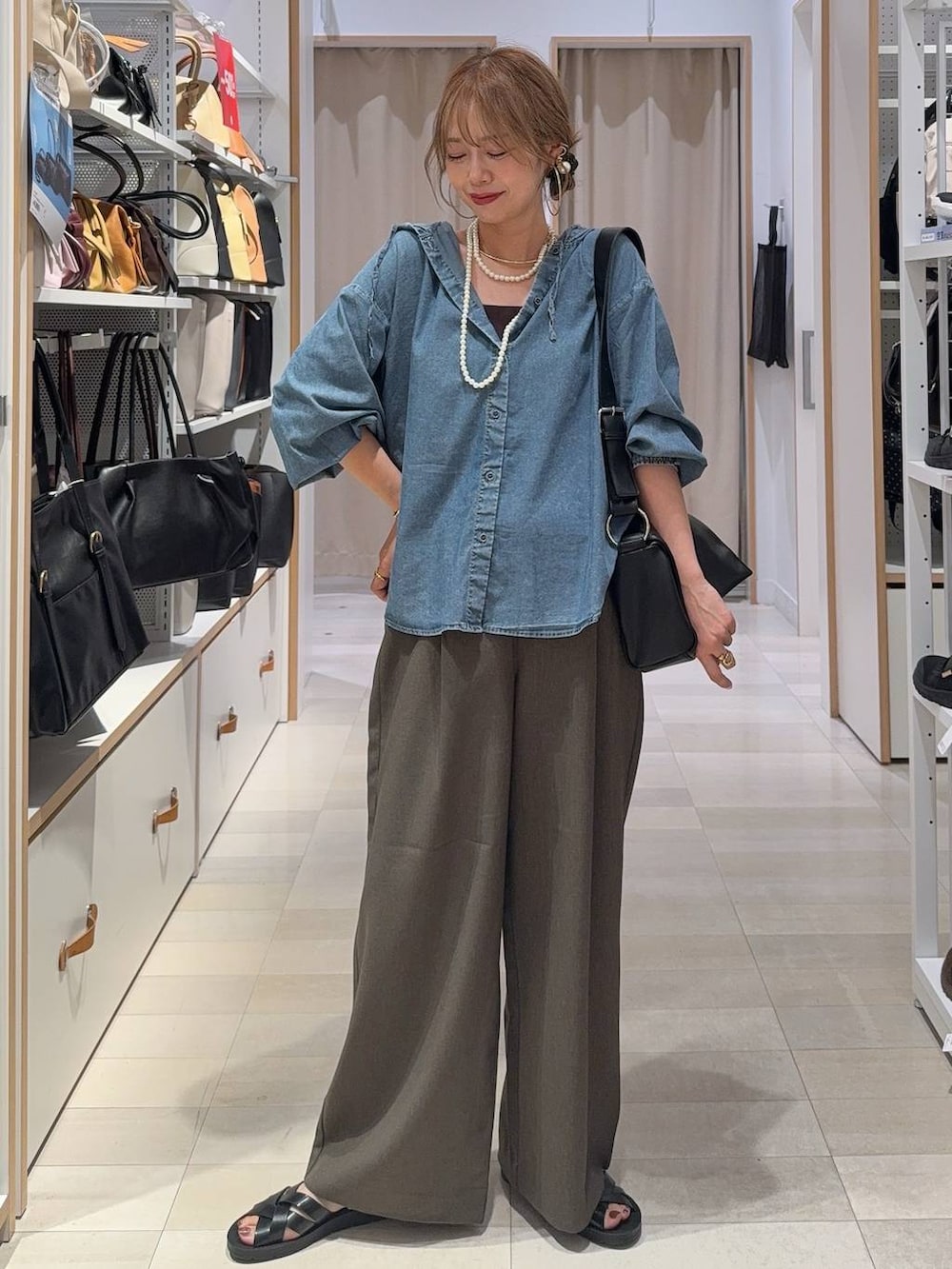 ベージュ系のベスト、ホワイト系のTシャツ/カットソー、ブラック系のサンダルを着用したレディースの夏コーディネートの3枚目の写真