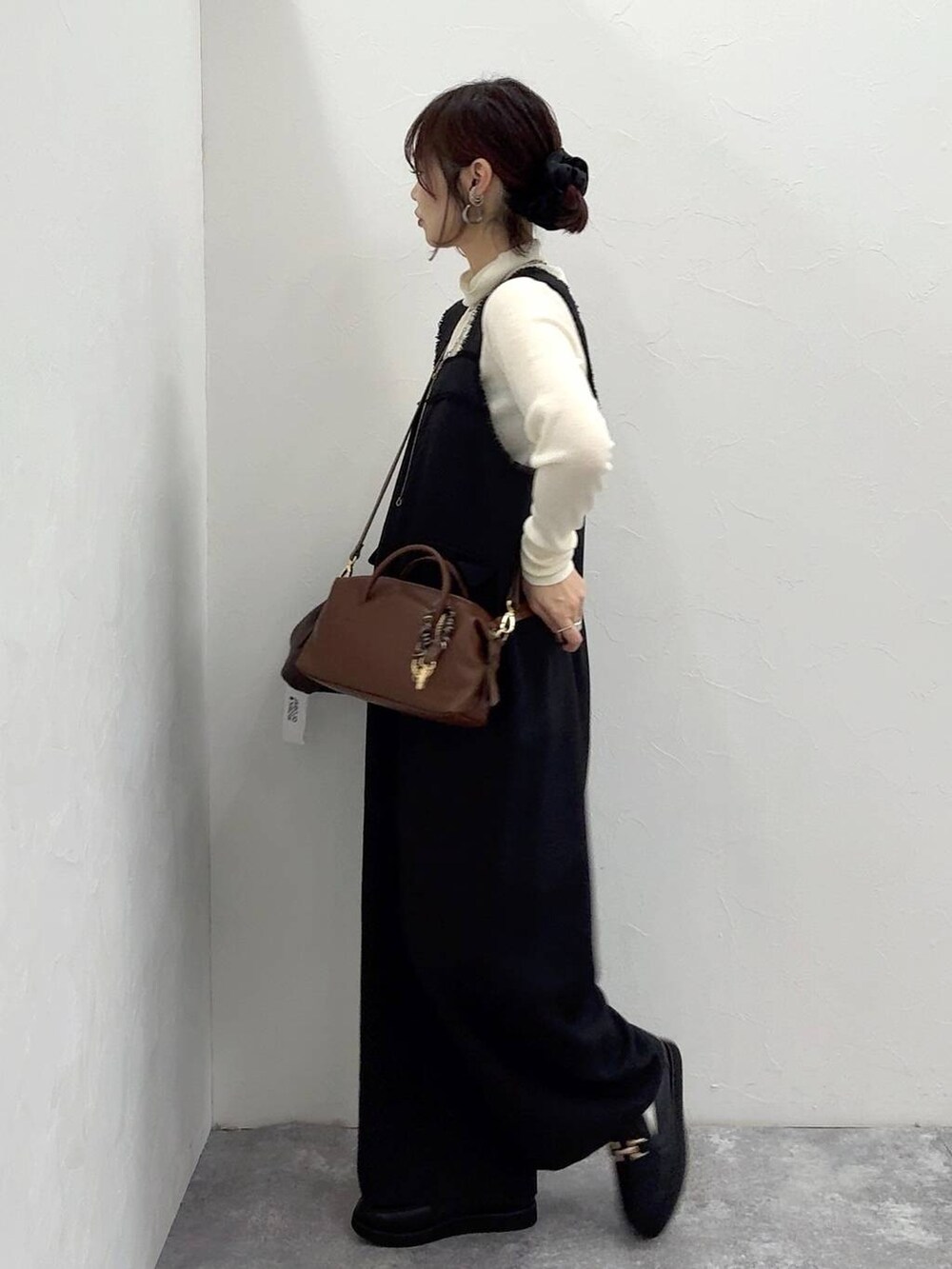 ブラック系のローファー、ブラック系のサロペット/オーバーオール、ホワイト系のニット/セーターを着用したレディースの冬コーディネートの5枚目の写真