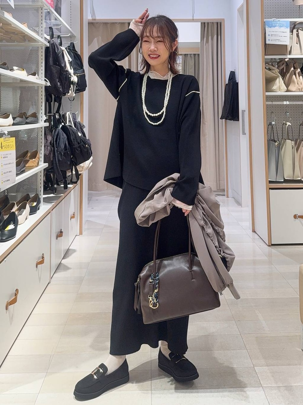 ブラック系のショルダーバッグ、ブラック系のワンピース、ブラウン系のその他パンツを着用したレディースの冬コーディネートの4枚目の写真