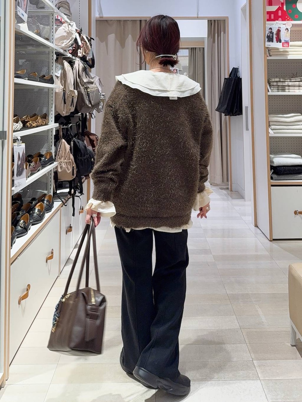 ブラウン系のボストンバッグ、ブラック系のブーツ、ブラウン系のカーディガン/ボレロを着用したレディースの冬コーディネートの6枚目の写真