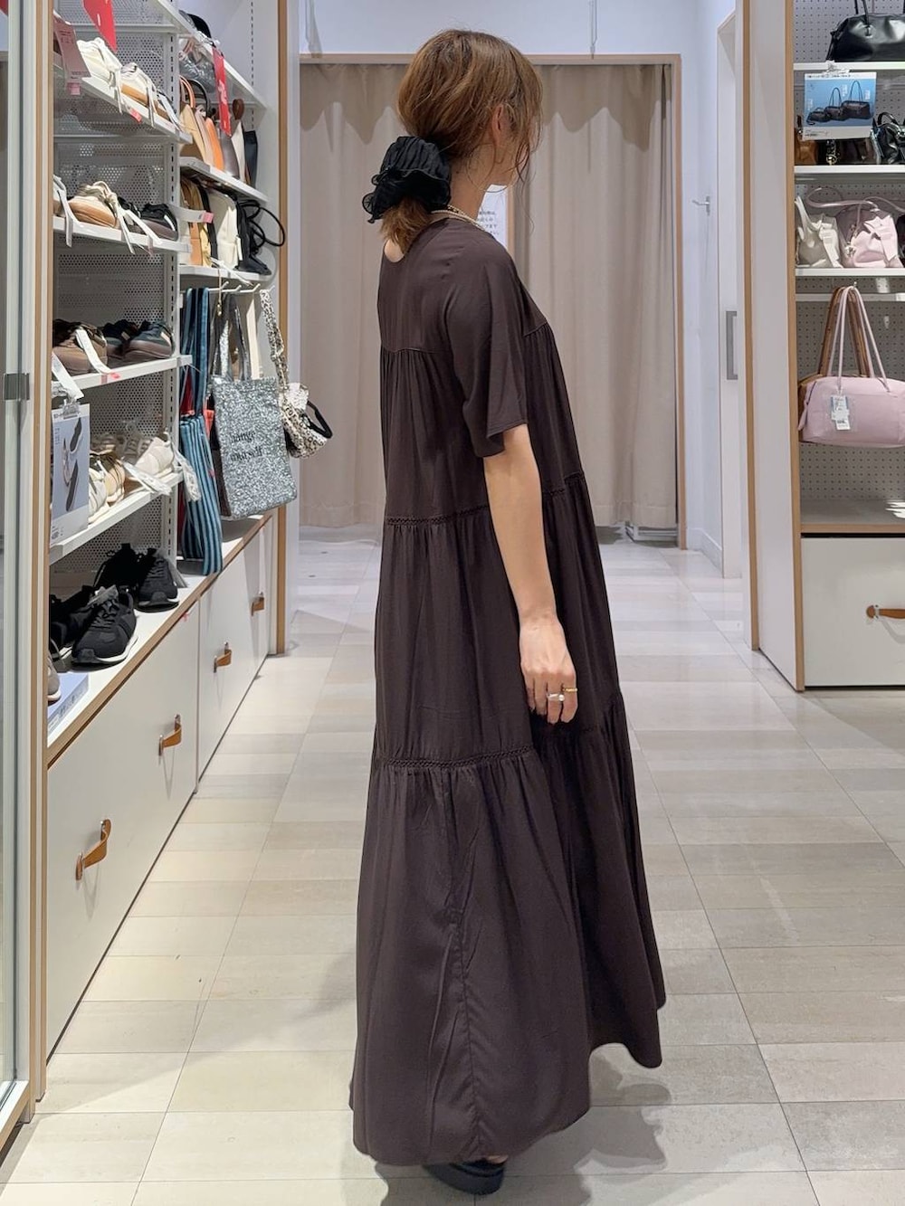ブルー系のデニムパンツ、ブラウン系のワンピース、ブラック系のサンダルを着用したレディースの夏コーディネートの6枚目の写真