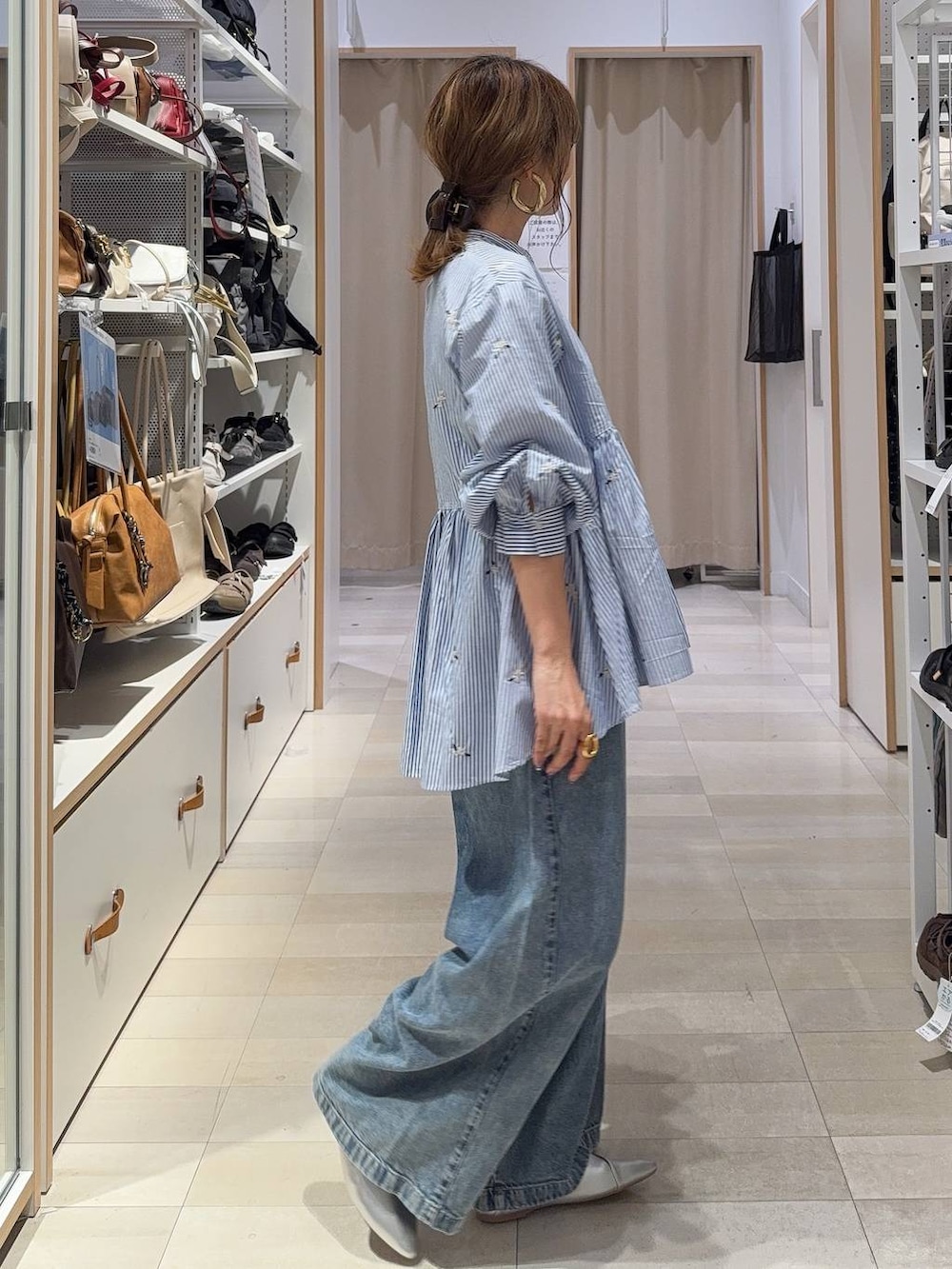 ブルー系のシャツ/ブラウス、シルバー系のパンプス、シルバー系のトートバッグを着用したレディースの秋コーディネートの5枚目の写真