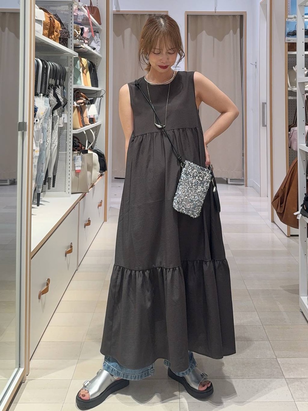 ブルー系のデニムパンツ、グレー系のワンピース、ブラウン系のTシャツ/カットソーを着用したレディースの夏コーディネートの2枚目の写真