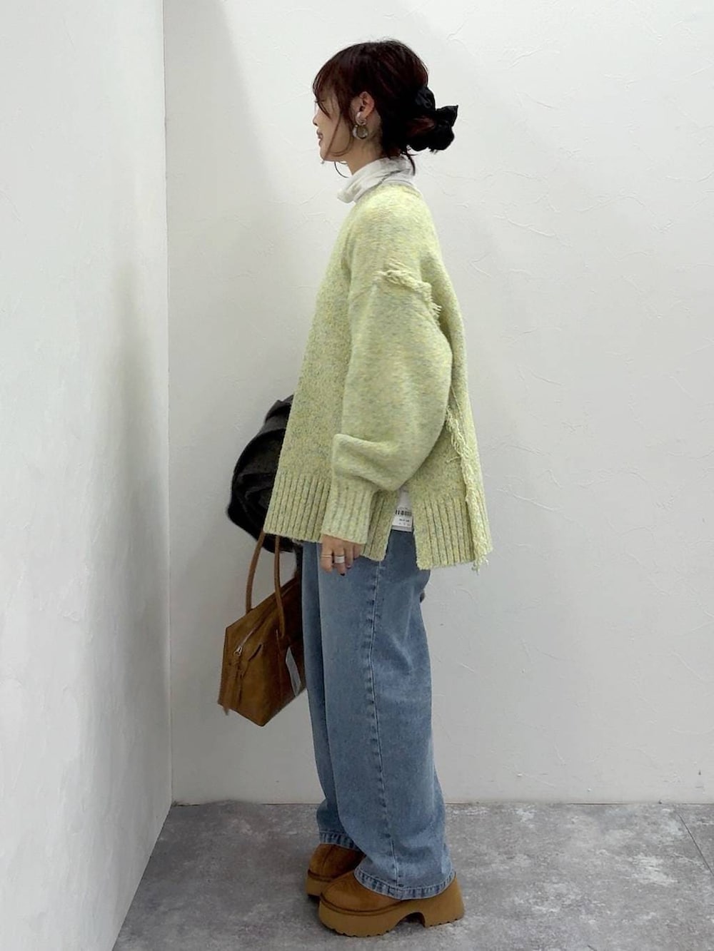 ベージュ系のボストンバッグ、グレー系のチェスターコート、イエロー系のブーツを着用したレディースの冬コーディネートの8枚目の写真