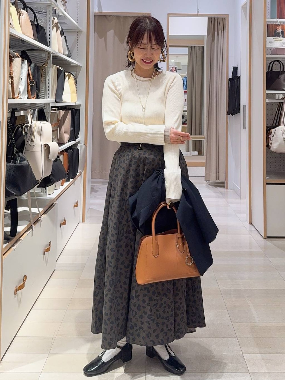 ブラウン系のショルダーバッグ、ブルー系のテーラードジャケット、その他のスカートを着用したレディースの冬コーディネートの2枚目の写真