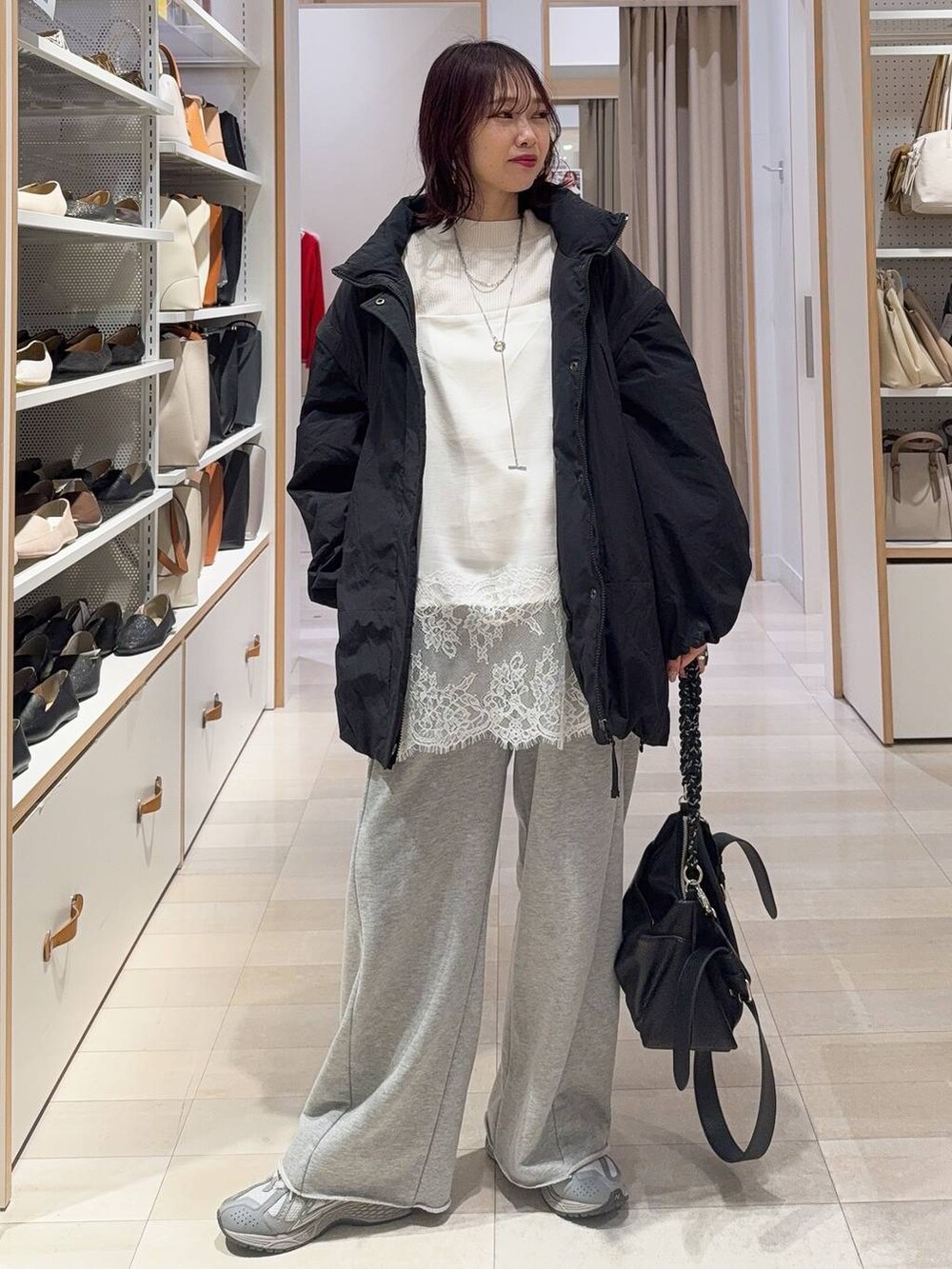 ホワイト系のニット/セーター、グレー系のスウェットパンツを着用したレディースの冬コーディネートの2枚目の写真