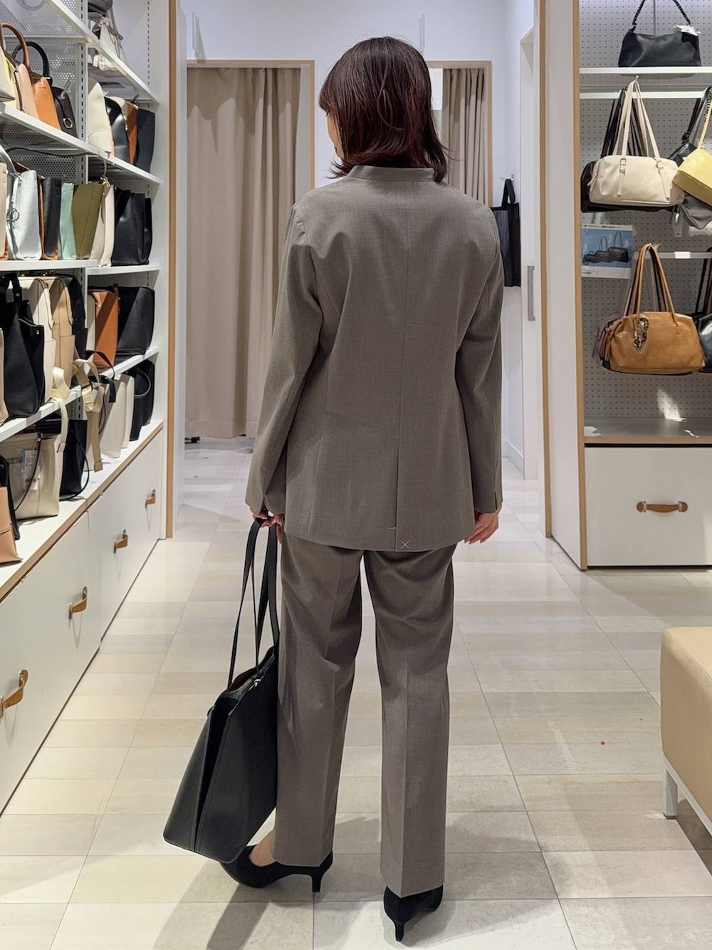 その他のパンプス、ブラウン系のスラックス、ブラック系のトートバッグを着用したレディースの春コーディネートの7枚目の写真