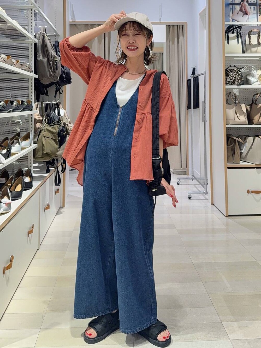 ブルー系のサロペット/オーバーオール、ブラック系のタンクトップ、ブラック系のショルダーバッグを着用したレディースの夏コーディネートの3枚目の写真