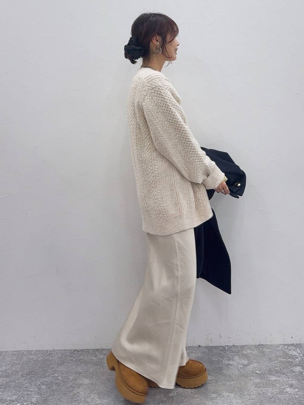 ホワイト系のスカート、ブルー系のチェスターコート、イエロー系のブーツを着用したレディースの冬コーディネートの5枚目の写真