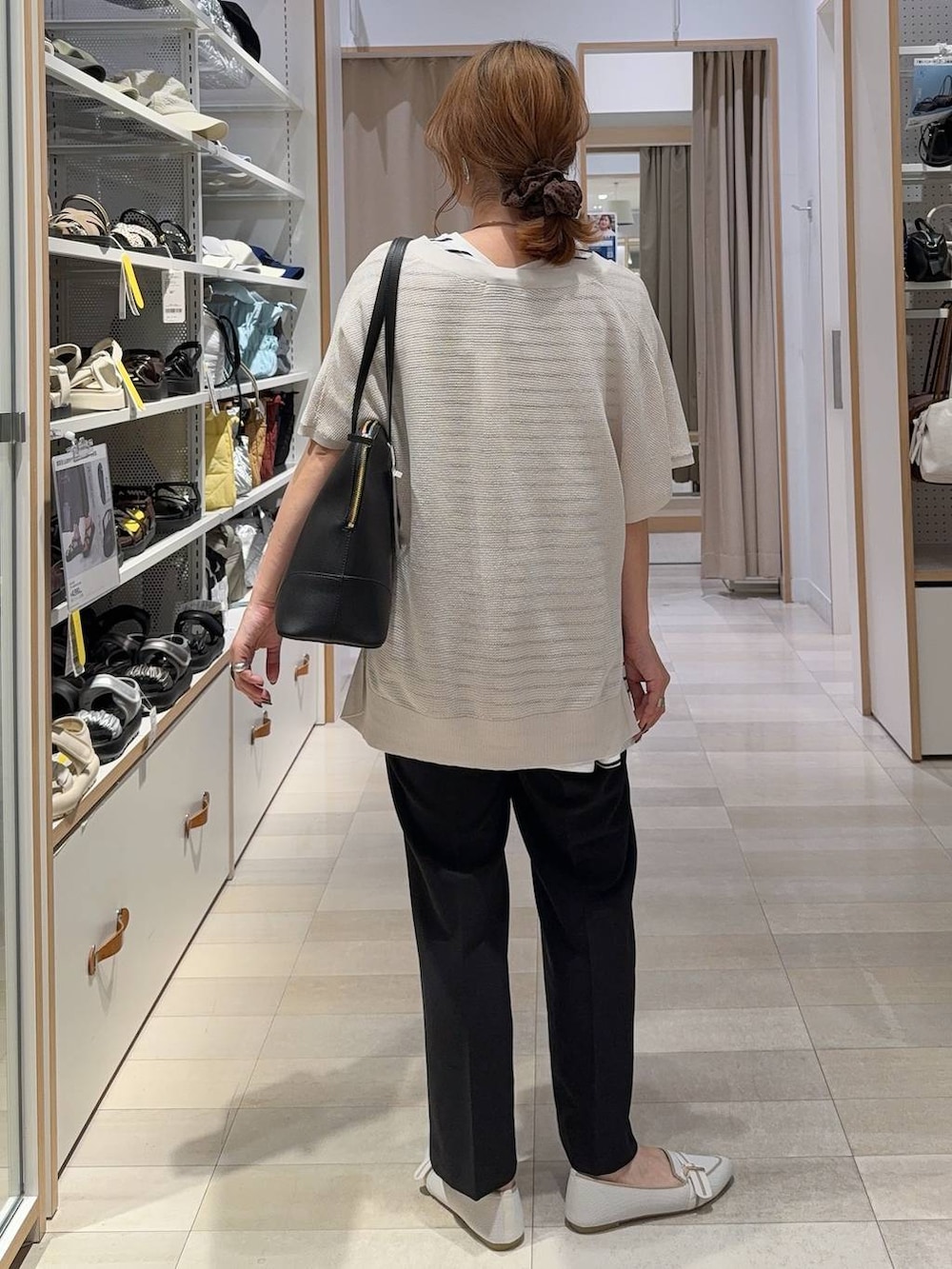 ホワイト系のパンプス、ブラック系のボストンバッグ、ブラック系のその他パンツを着用したレディースの夏コーディネートの7枚目の写真