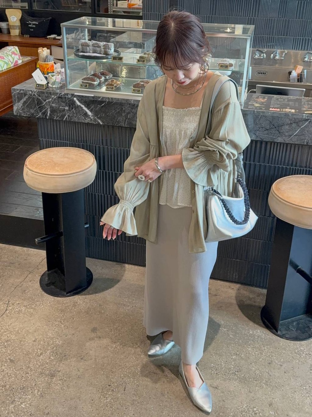 ホワイト系のスカート、グレー系のその他パンツ、ホワイト系のベストを着用したレディースの春コーディネートの2枚目の写真