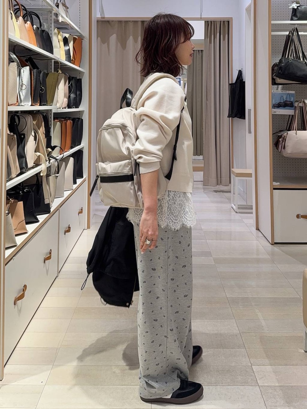 ブラック系のスニーカー、ホワイト系のバックパック/リュック、ブラック系のマウンテンパーカーを着用したレディースの春コーディネートの5枚目の写真