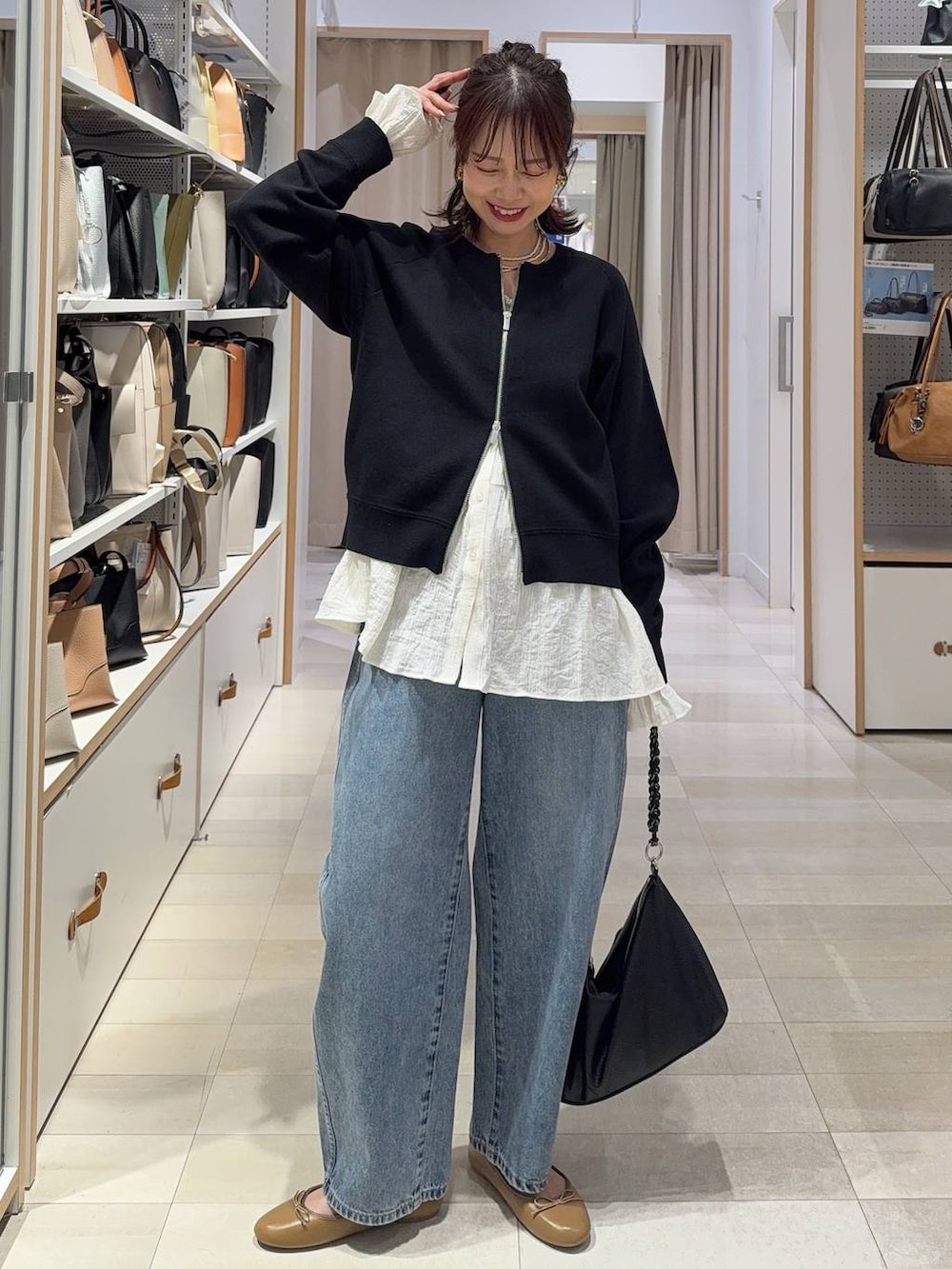 ブラック系のTシャツ/カットソー、ブラック系のスラックス、ブルー系のデニムパンツを着用したレディースの春コーディネートの3枚目の写真