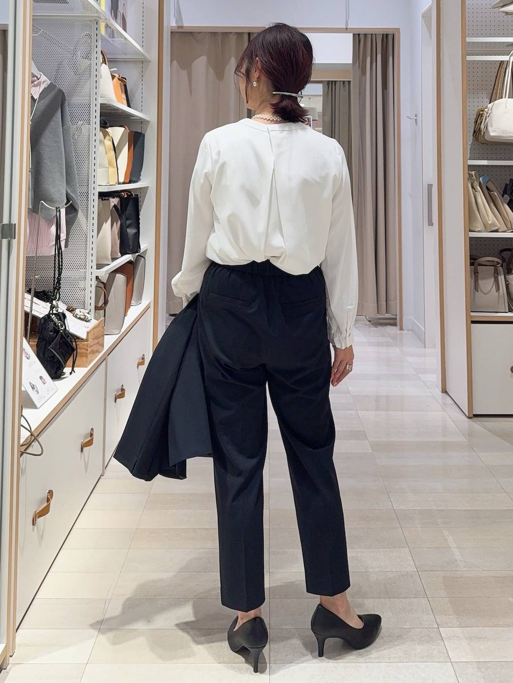 ブラック系のショルダーバッグ、ブルー系のスラックス、ホワイト系のシャツ/ブラウスを着用したレディースの冬コーディネートの7枚目の写真