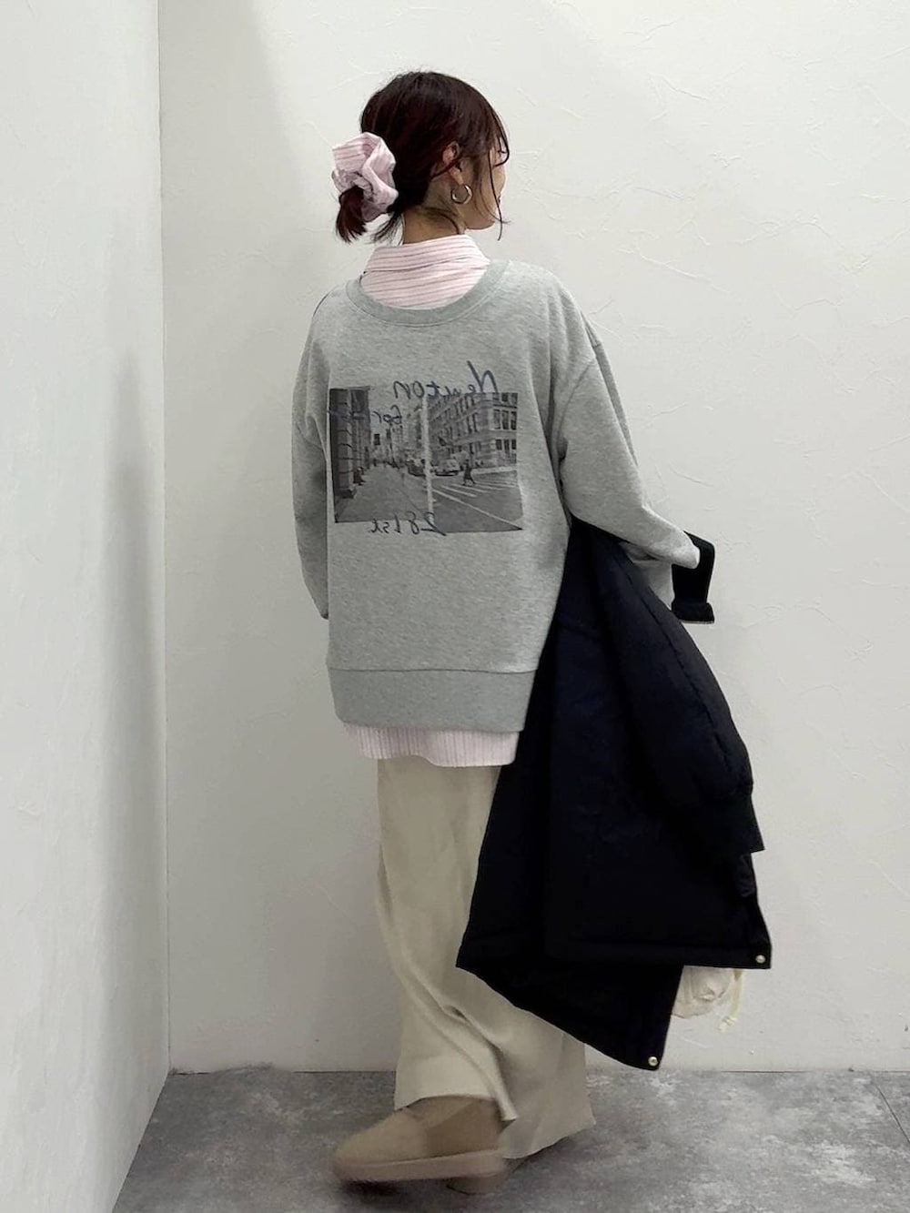 ホワイト系のショルダーバッグ、ブラック系のダウンジャケット/コート、ホワイト系のスカートを着用したレディースの冬コーディネートの7枚目の写真