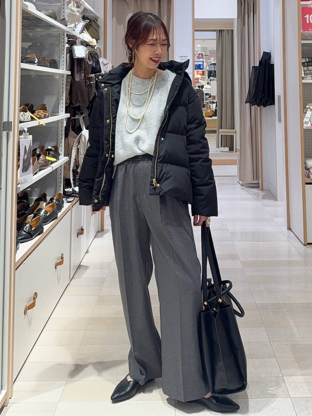 ブラック系のダウンジャケット/コート、ホワイト系のTシャツ/カットソー、ブラウン系のニット/セーターを着用したレディースの冬コーディネートの4枚目の写真