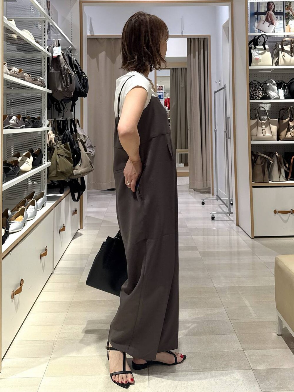 ブルー系のデニムパンツ、ブラック系のトートバッグ、グリーン系のTシャツ/カットソーを着用したレディースの春コーディネートの8枚目の写真