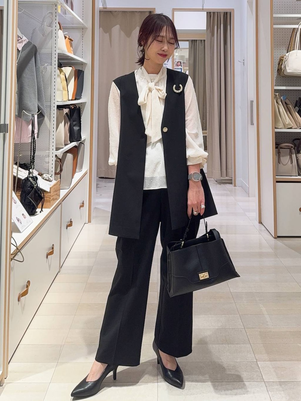 ブラック系のシャツ/ブラウス、ブラック系のスラックス、ブラック系のその他アウターを着用したレディースの冬コーディネートの3枚目の写真