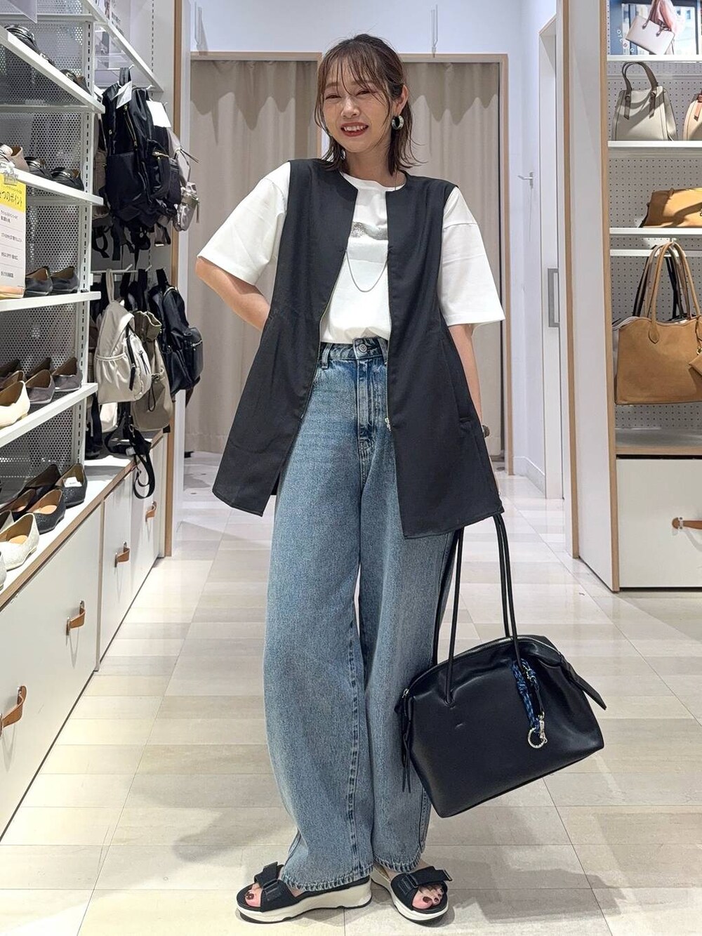 シルバー系のショルダーバッグ、ブラック系のTシャツ/カットソー、シルバー系のサンダルを着用したレディースの夏コーディネートの4枚目の写真