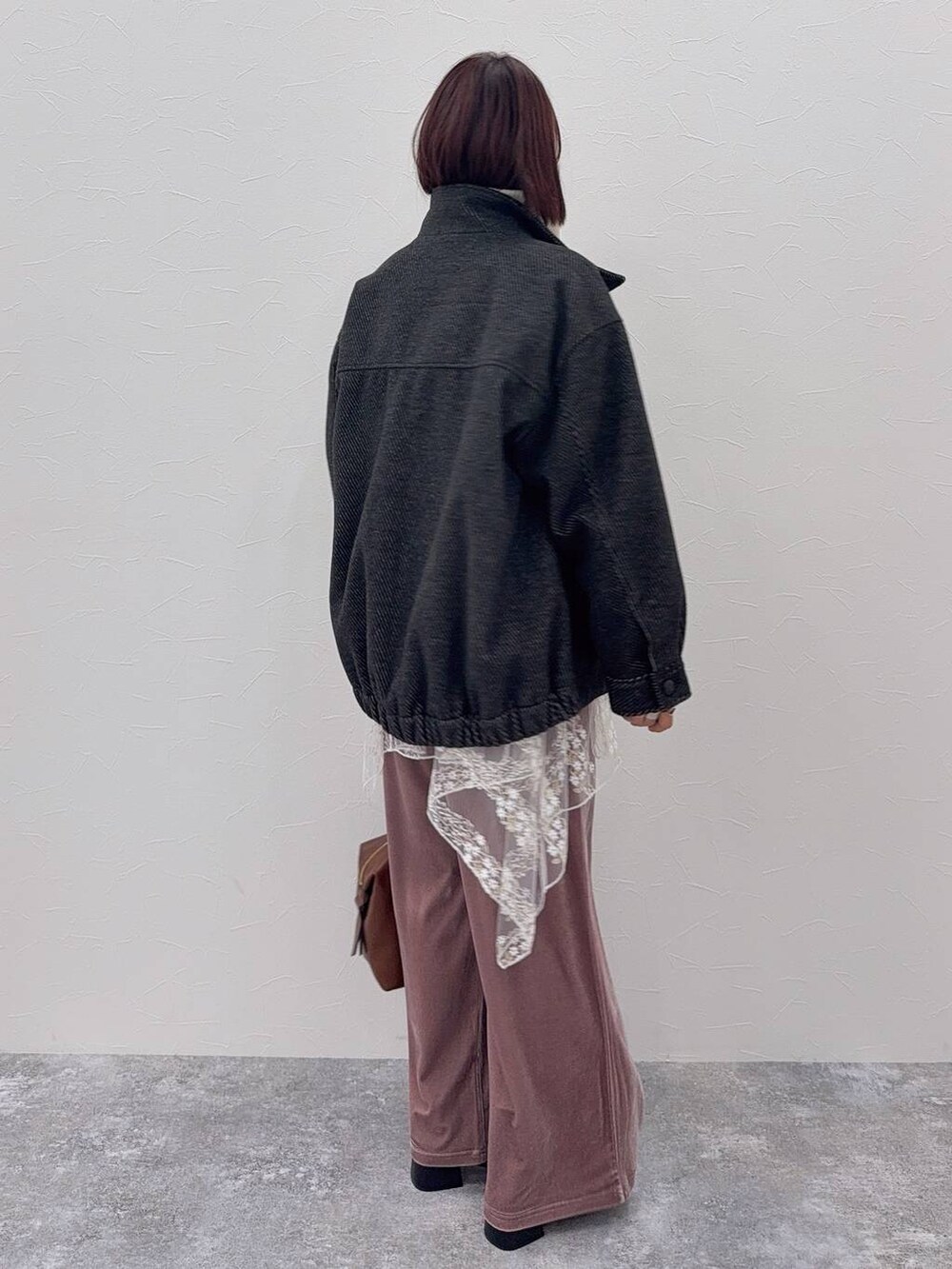 ブラウン系のボストンバッグ、ブラック系のブーツ、ホワイト系のその他トップスを着用したレディースの秋コーディネートの4枚目の写真