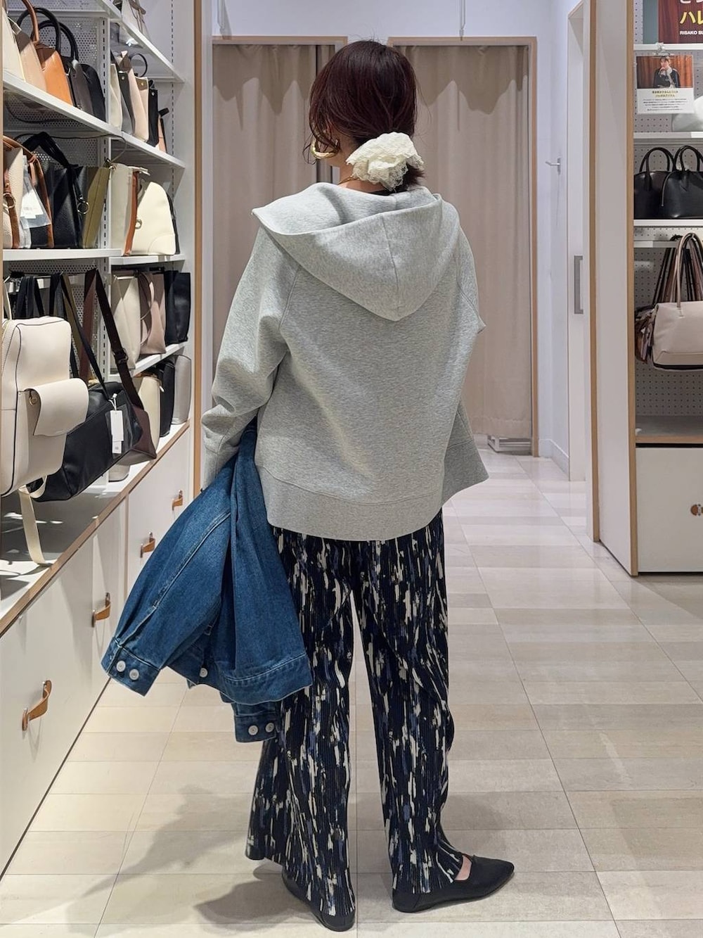 ブラック系のショルダーバッグ、ブラック系のパンプス、グレー系のパーカーを着用したレディースの春コーディネートの9枚目の写真