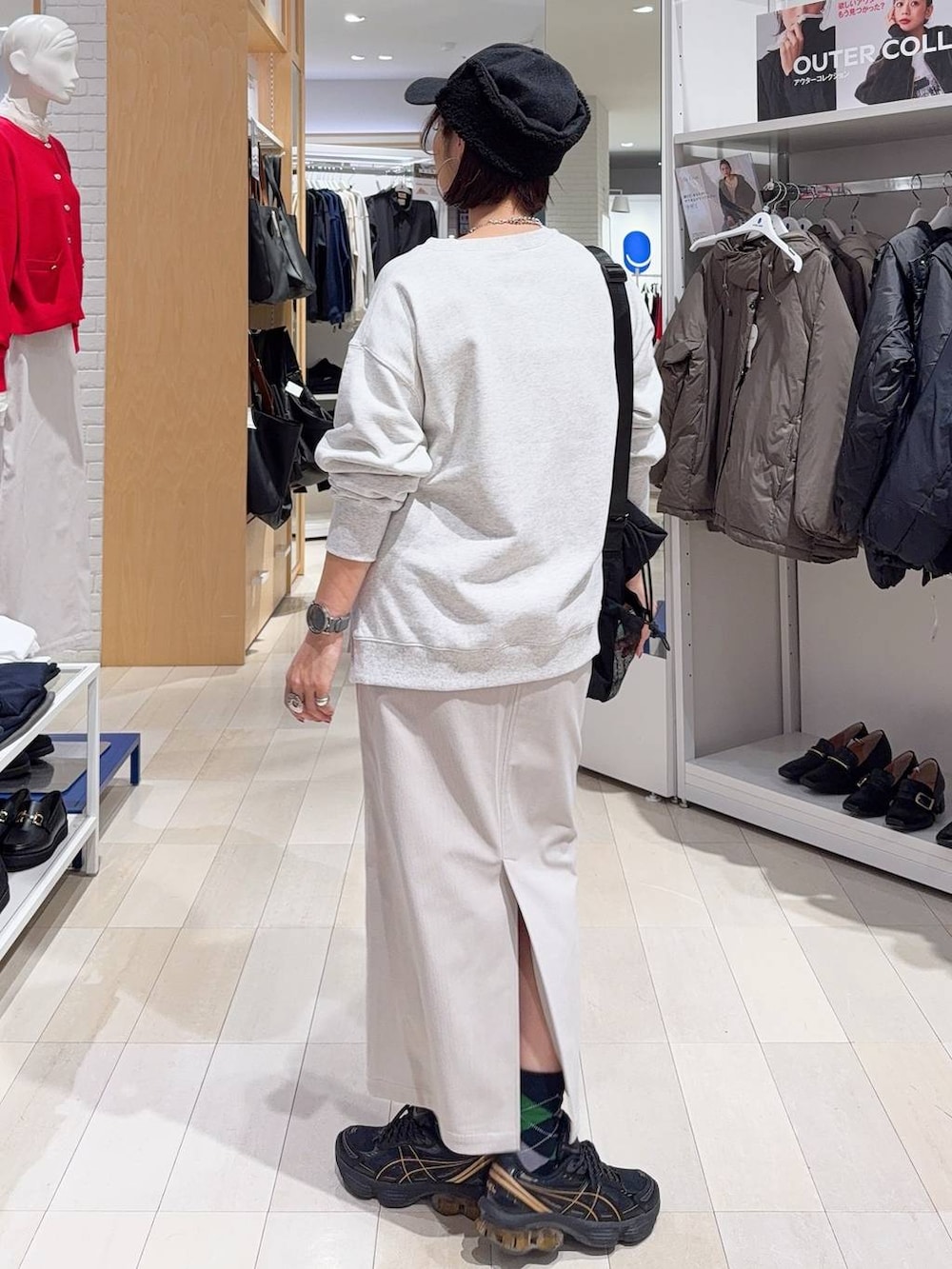 ブラック系のトートバッグ、ブルー系のカーディガン/ボレロ、グレー系のスカートを着用したレディースの秋コーディネートの9枚目の写真