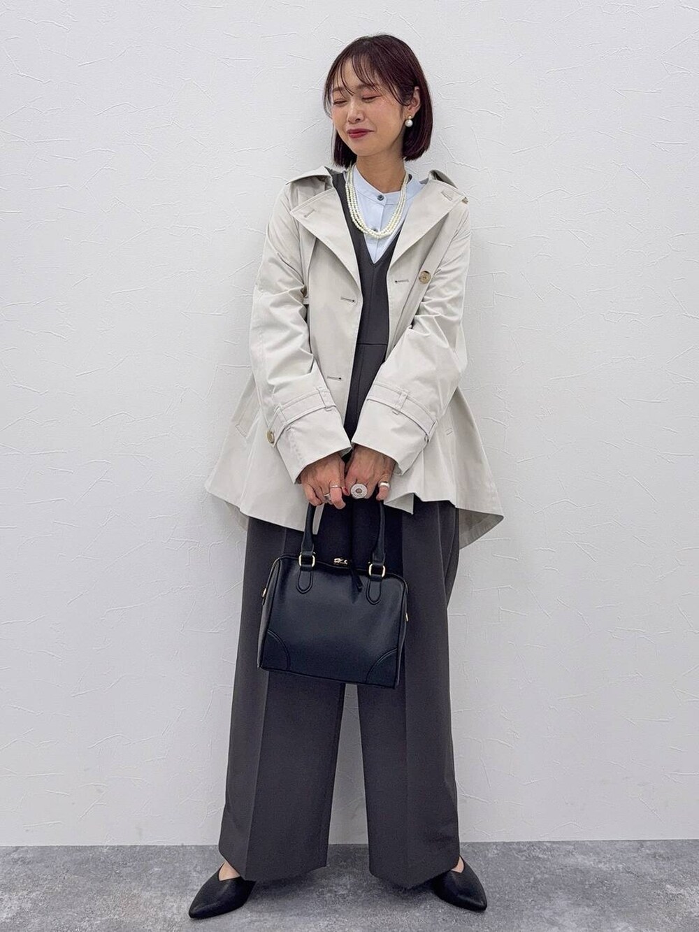 グレー系のセットアップ、ブラック系のボストンバッグ、その他のネックレスを着用したレディースの秋コーディネートの2枚目の写真