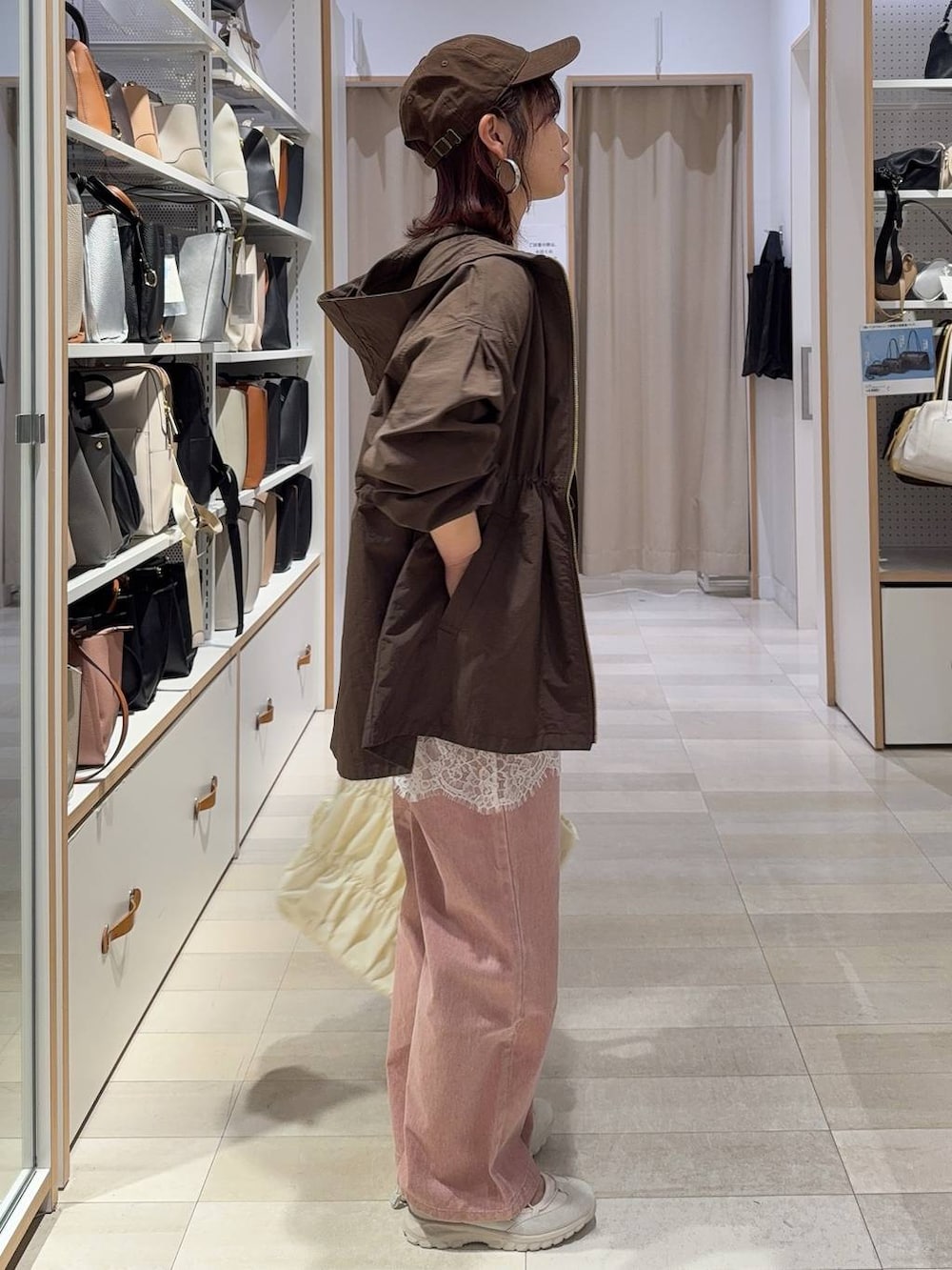 ベージュ系のトートバッグ、ブラウン系のパーカー、ピンク系のデニムパンツを着用したレディースの春コーディネートの4枚目の写真