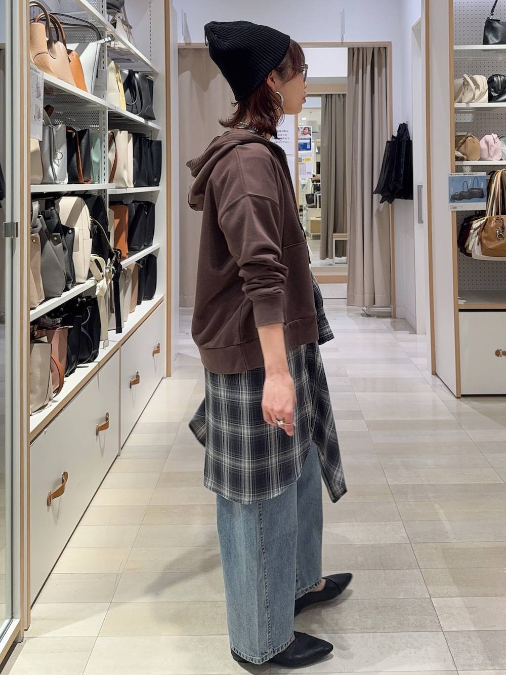 ブラック系のパンプス、ブラック系のハンドバッグ、ブルー系のデニムパンツを着用したレディースの春コーディネートの5枚目の写真