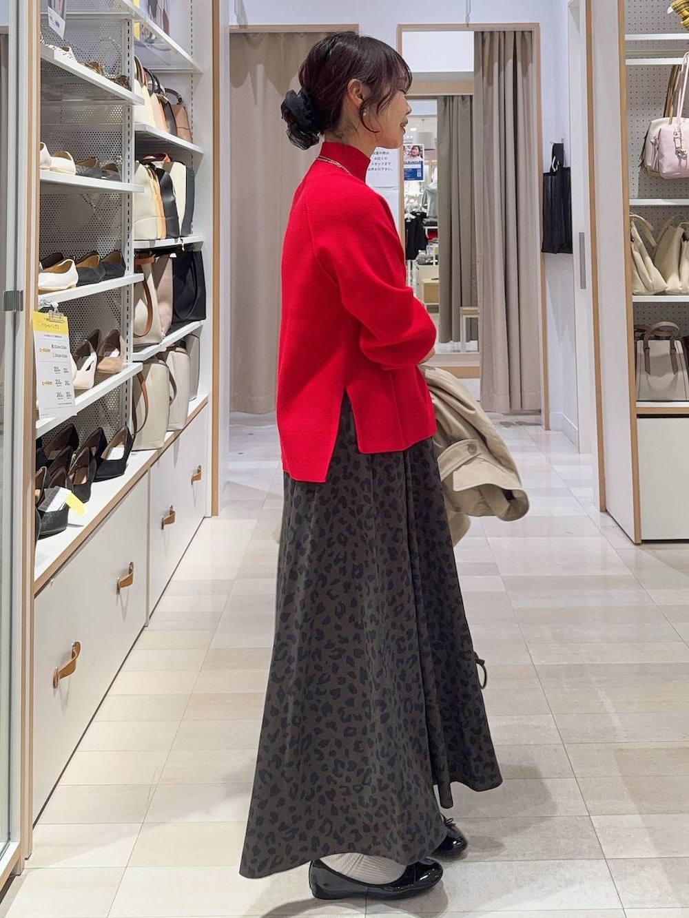 ブラック系のバレエシューズ、レッド系のニット/セーター、ベージュ系のトレンチコートを着用したレディースの冬コーディネートの6枚目の写真